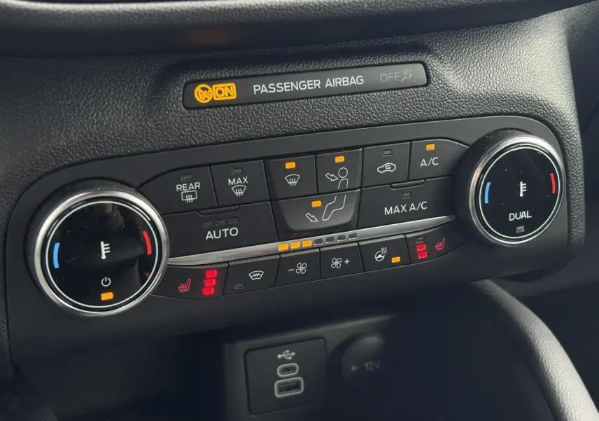 Gros plan sur la console de climatisation double zone avec commandes chauffantes du Ford Kuga 2023.