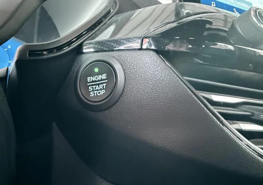 Gros plan sur le bouton Start/Stop moteur et partie de la console noire brillante du Ford Kuga 2023.