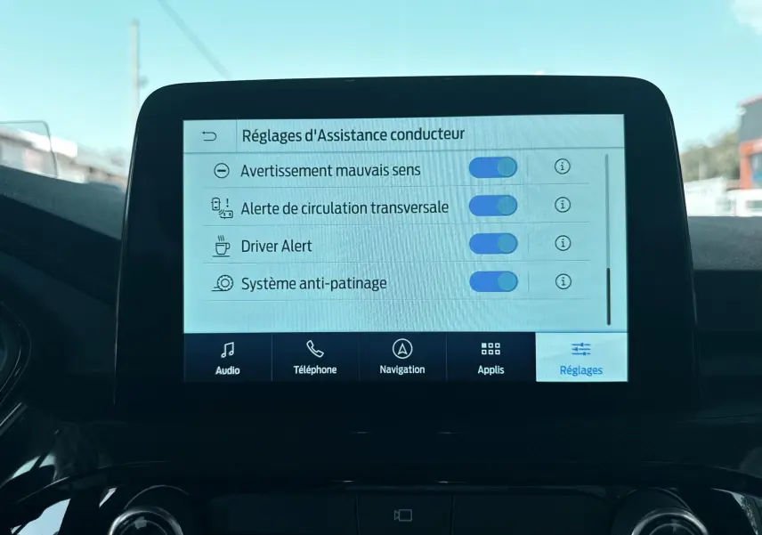 Écran tactile central du Ford Kuga bleu azur 2023 affichant les réglages d'assistance conducteur en mode réglages.