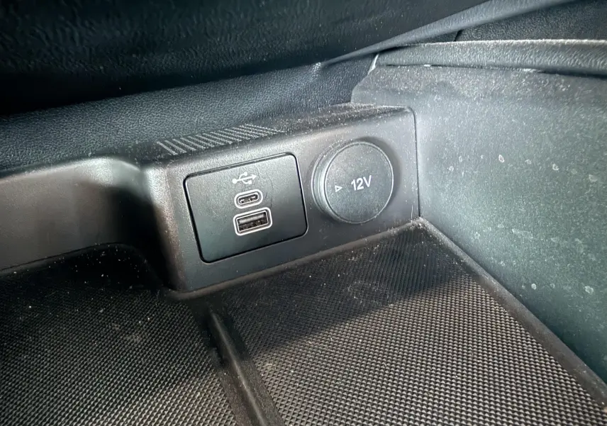 Gros plan sur la prise USB et la prise 12V dans l'habitacle noir du Ford Kuga 2023 version ST-Line X.