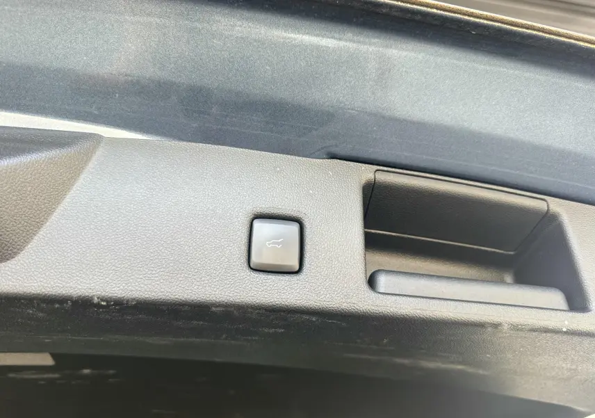 Bouton d'ouverture électrique du hayon sur le coffre d'un Ford Kuga bleu azur 2023, version ST-Line X.