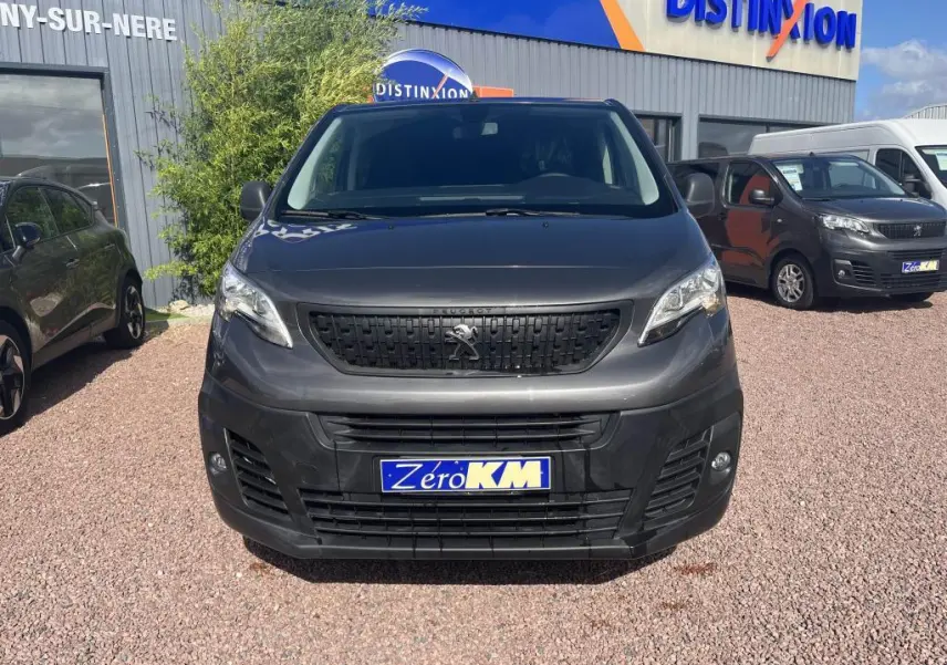 Vue frontale d'un Peugeot Expert Fourgon gris platinium métal avec calandre noire et plaque Zero KM.