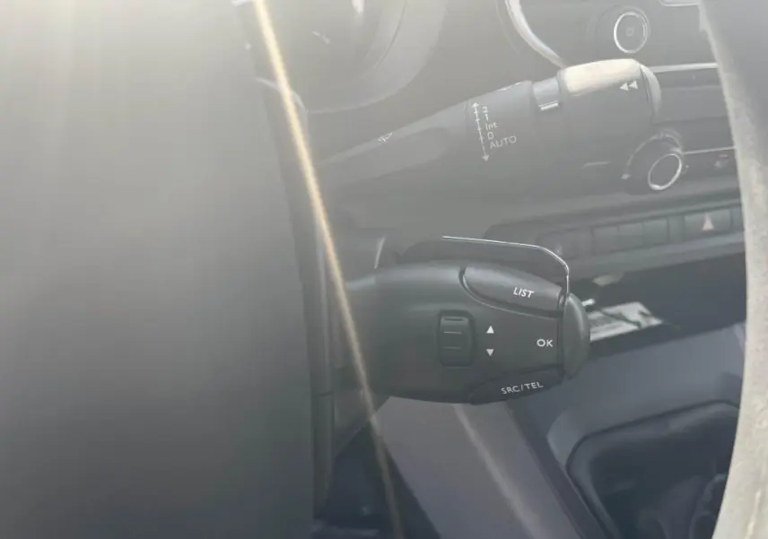 Gros plan sur la commande multifonction au volant du Peugeot Expert Fourgon gris platinium, intérieur côté conducteur.