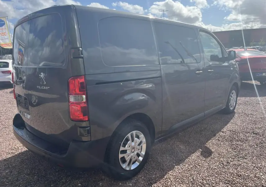 Vue 3/4 arrière droit d'un Peugeot Expert Fourgon gris platinium métallisé avec portes latérales et feux arrière visibles.