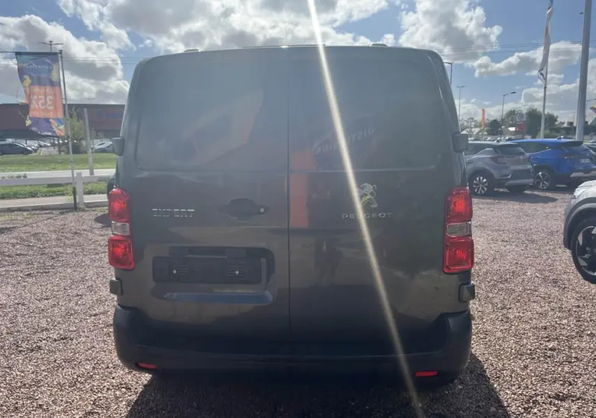 Vue arrière d'un Peugeot Expert Fourgon gris platinium métal avec portes battantes et feux rouges visibles.