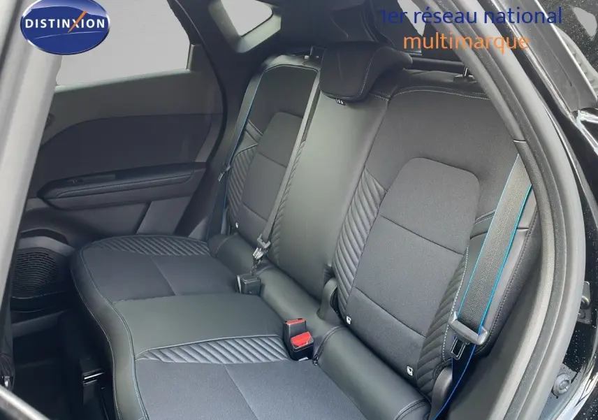 Vue intérieure arrière du Renault Captur noir étoile avec sellerie mixte cuir et tissu noir soulignée de surpiqûres bleues.