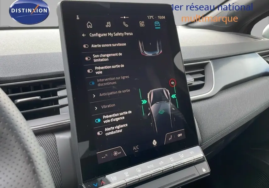Écran tactile central du tableau de bord du Renault Captur E-Tech hybride 2025, ambiance intérieure moderne et noire.