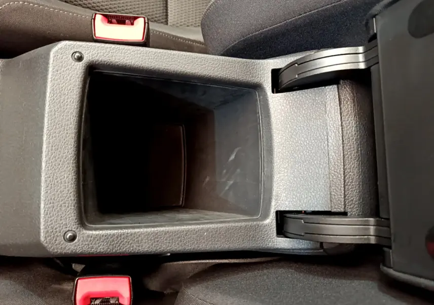 Gros plan sur la console centrale ouverte en plastique gris avec sièges noirs de la Volkswagen Golf 2019.