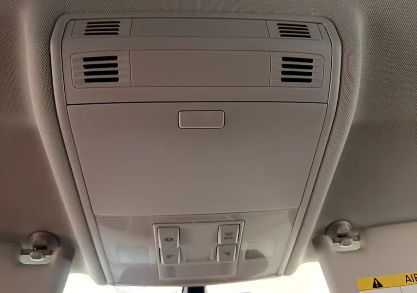 Vue intérieure du plafonnier gris clair de la Volkswagen Golf 2019, avec commandes d'éclairage et aérations intégrées.