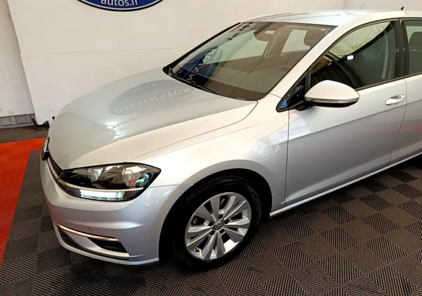 Vue 3/4 avant droit d'une Volkswagen Golf gris clair avec phares LED et jantes alliage visibles.