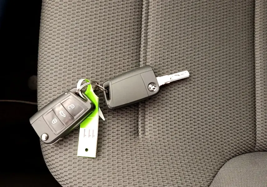 Clé de voiture Volkswagen Golf 1.6 TDI 2019 posée sur un siège tissu gris foncé à motifs géométriques.