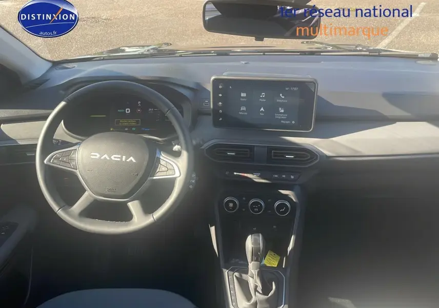 Vue intérieure frontale du tableau de bord du Dacia Jogger noir nacré avec écran tactile et volant multifonction.