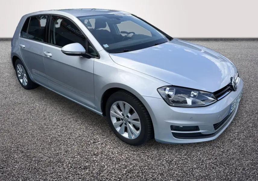 Volkswagen Golf gris clair vue 3/4 avant droit, avec phares halogènes et rétroviseurs électriques rabattables.