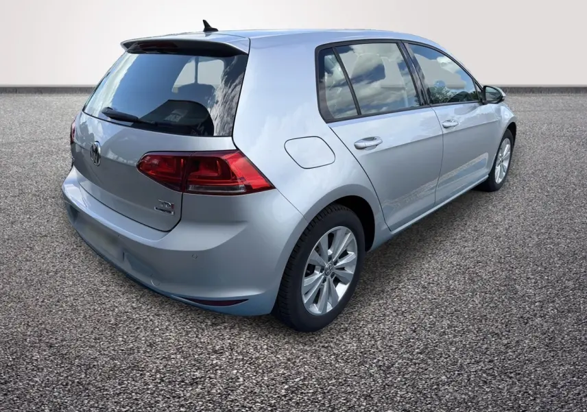 Vue 3/4 arrière droite d'une Volkswagen Golf gris clair, avec feux arrière LED et jantes alliage visibles.