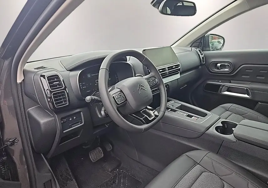 Intérieur vue côté conducteur du Citroën C5 Aircross gris, avec tableau de bord moderne et écran tactile central.