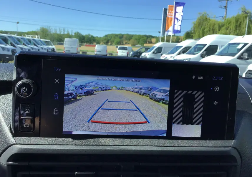 Écran de caméra de recul du Peugeot Expert Fourgon blanc, vue arrière avec lignes de guidage et parking de véhicules blancs.