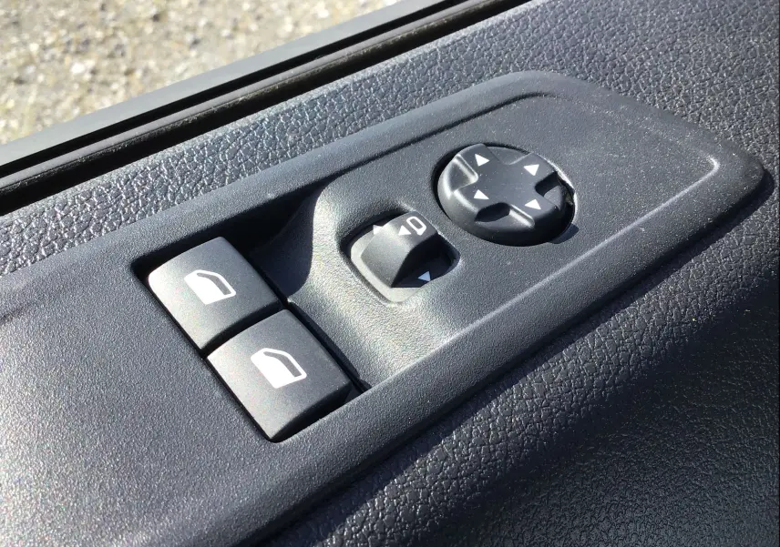 Gros plan sur les commandes de réglage des rétroviseurs et des vitres côté conducteur du Peugeot Expert Fourgon blanc 2025.