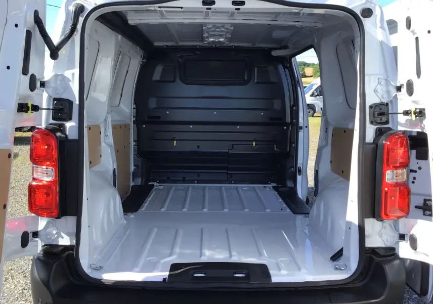 Vue arrière ouverte du fourgon blanc Peugeot Expert M 1.5 BlueHDi 120, montrant l’espace de chargement vide et les feux arrière rouges.