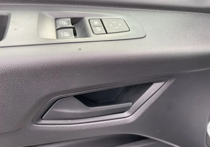 Poignée intérieure et commandes des vitres côté conducteur du Renault Master IV FG 3T5 blanc, vue rapprochée.