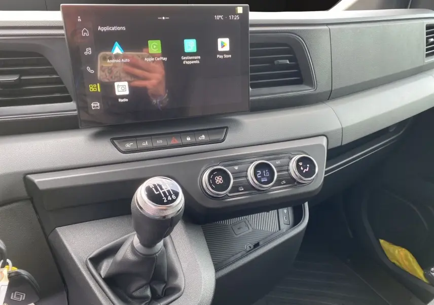 Vue intérieure du tableau de bord du Renault Master 2025 avec boîte manuelle, écran tactile et commandes de climatisation.