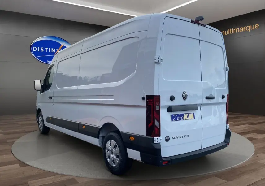 Renault Master blanc vu 3/4 arrière droit, portes arrière tôlées ouvertes à 270°, enjoliveurs noirs visibles.