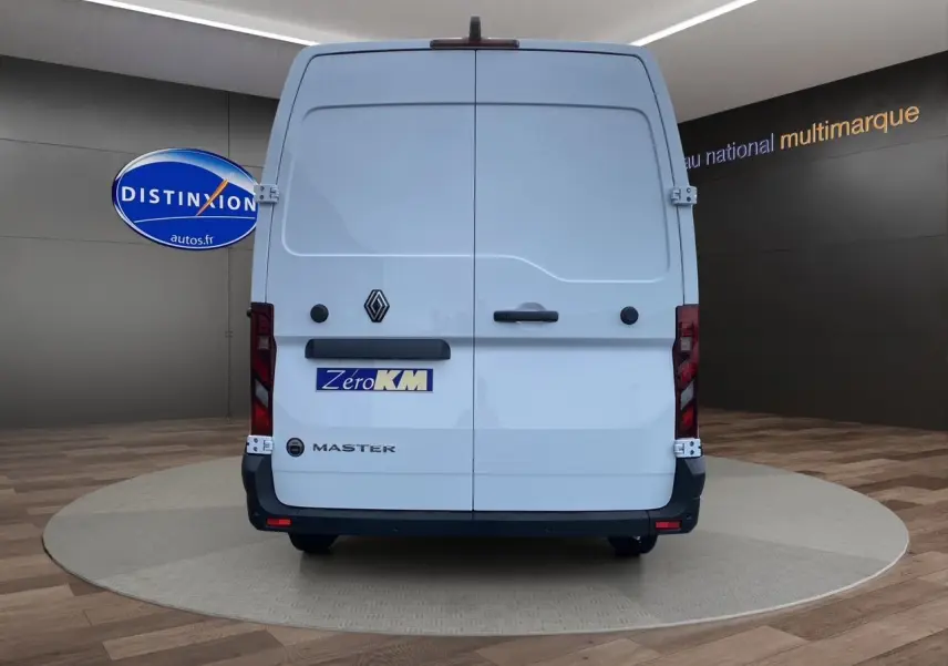 Vue arrière d'un Renault Master blanc avec portes tôlées et logo Zero KM visible en showroom.