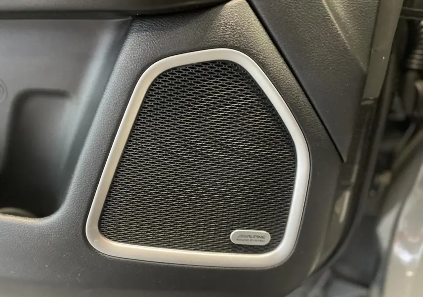 Gros plan sur l'enceinte Alpine intégrée à la porte intérieure d'un Jeep Compass gris foncé Trailhawk 2021.