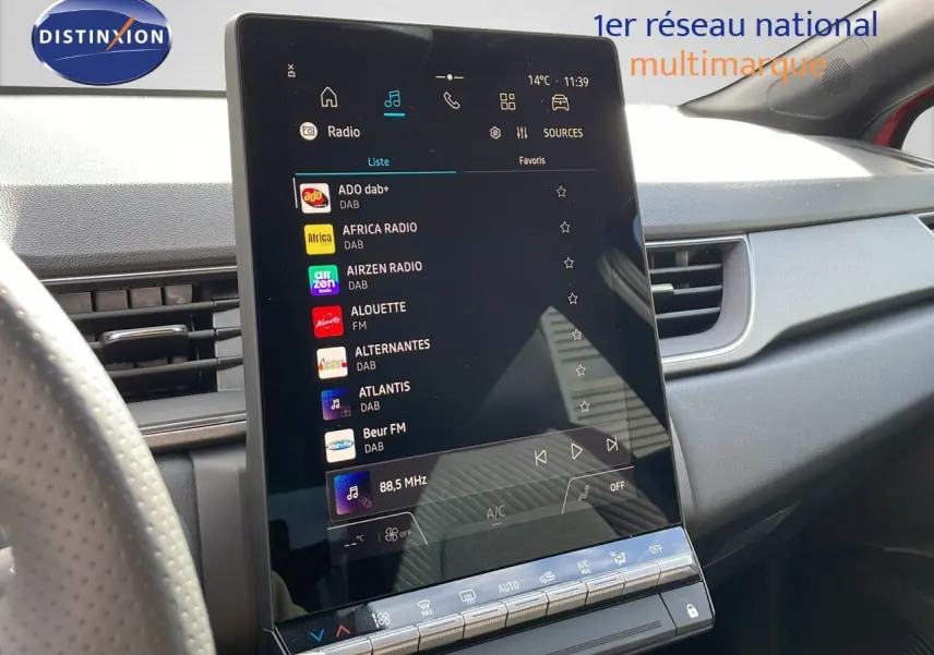 Écran tactile central affichant les stations radio dans l’habitacle du Renault Captur E-Tech hybride rouge toit noir.