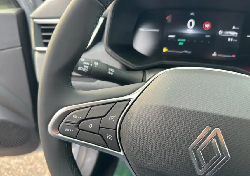 Gros plan sur le volant cuir multifonctions de la Renault Clio DCI 100 Evolution Camera avec commandes intégrées.