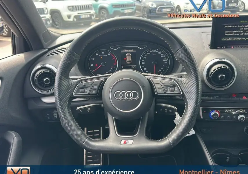 Vue intérieure centrée sur le volant sport multifonctions d'une Audi A3 Sportback gris clair avec tableau de bord digital.