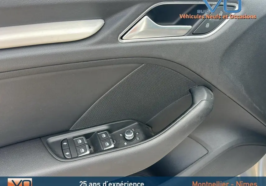 Détail de la porte côté conducteur de l'Audi A3 Sportback gris clair avec commandes des vitres et verrouillage.