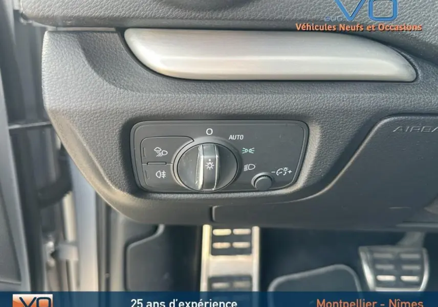 Commande des phares avec réglage automatique sur tableau de bord noir d'Audi A3 Sportback gris clair, vue intérieure côté gauche.