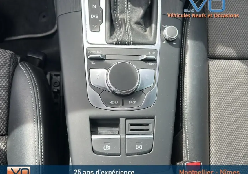 Vue rapprochée de la console centrale grise de l'Audi A3 Sportback 2018 avec levier de vitesses et accoudoir en cuir noir.