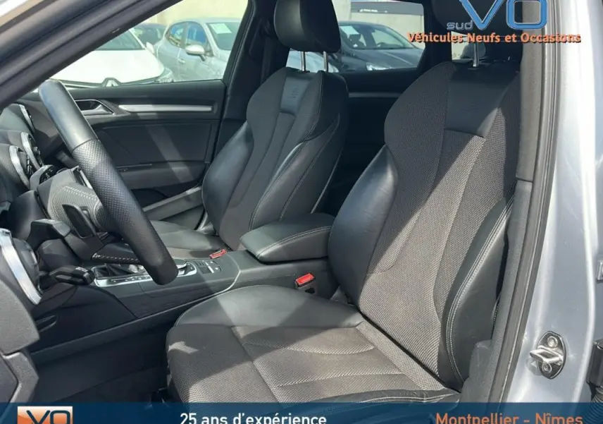 Intérieur de l'Audi A3 Sportback gris clair, vue côté gauche montrant sièges sport et volant multifonctions cuir perforé.