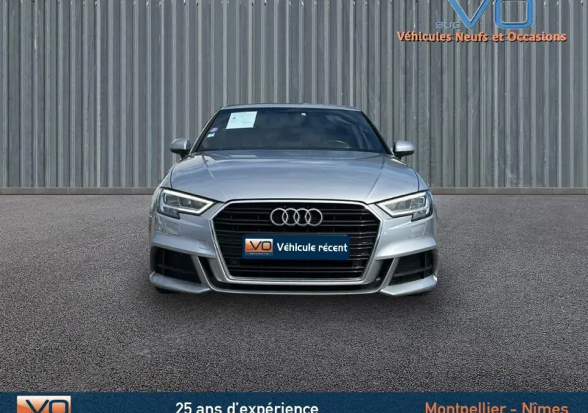 Vue frontale d'une Audi A3 Sportback gris clair 2018 avec calandre noire et phares LED distinctifs.