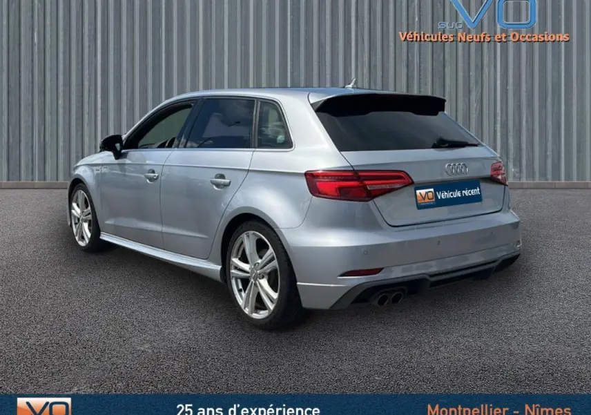 Audi A3 Sportback gris clair vue 3/4 arrière droit, avec jantes alliage et vitres teintées.