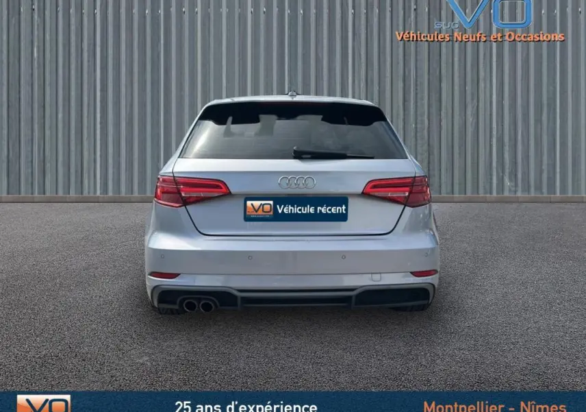 Vue arrière d'une Audi A3 Sportback gris clair de 2018 avec feux LED et double sortie d'échappement à gauche.