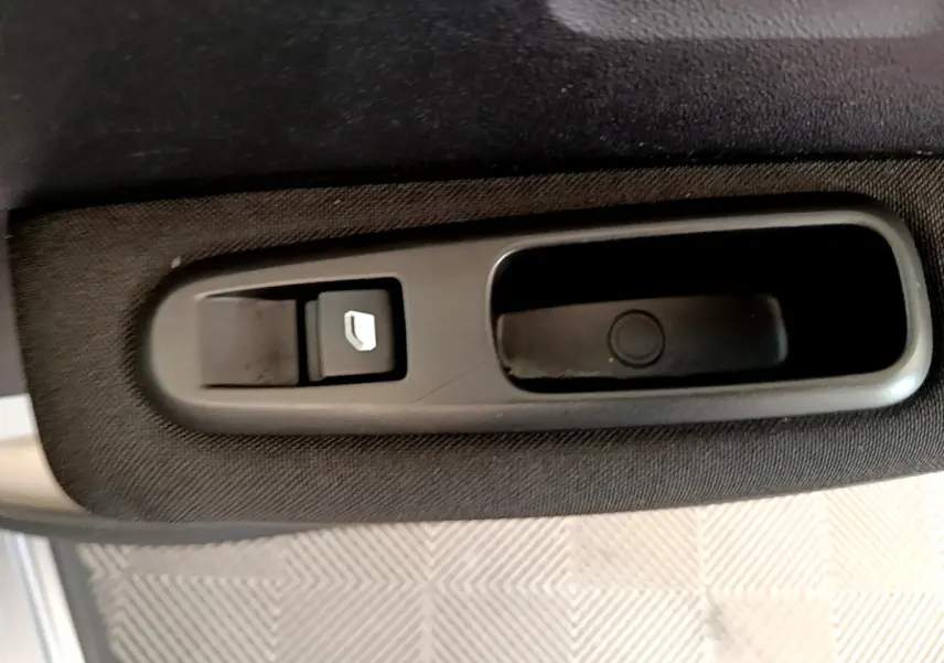 Détail de la commande de lève-vitre électrique sur la porte intérieure côté conducteur d'une Citroën C3 gris clair 2019.