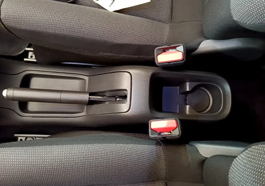 Vue plongeante sur la console centrale noire avec frein à main manuel et sièges tissu gris foncé de la Citroën C3 2019.