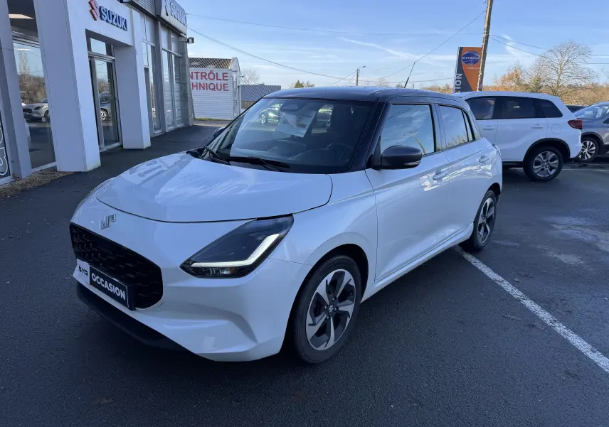 Suzuki Swift 1.2 Dualjet Pack Auto Hybride blanc et gris vue 3/4 avant sur parking devant concession.