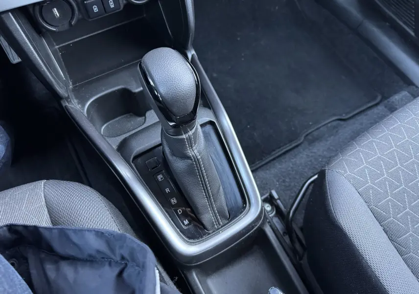 Le levier de vitesse automatique en cuir noir de la Suzuki Swift 2024, vue rapprochée de la console centrale intérieure.