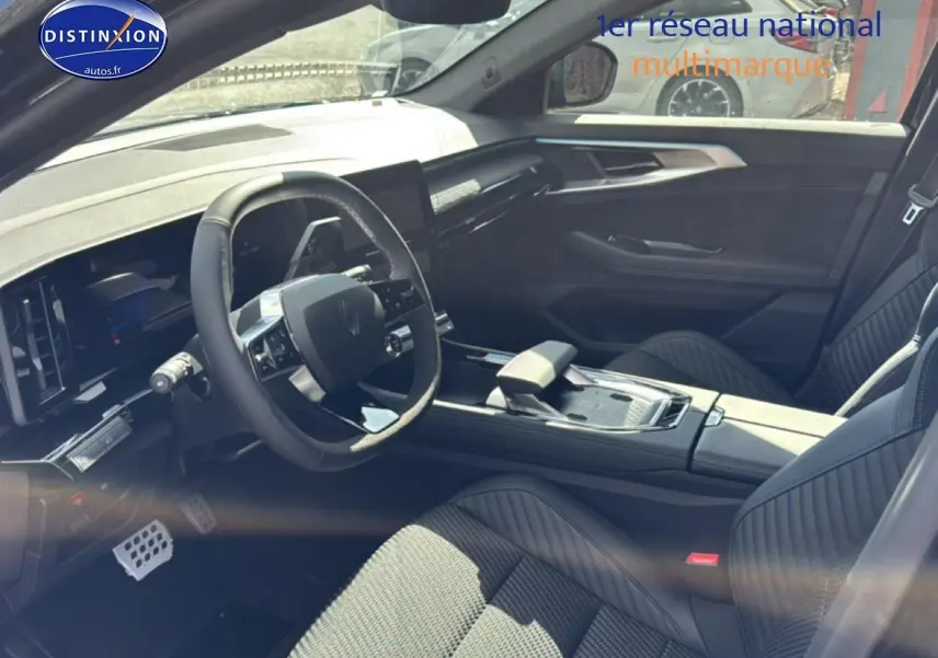 Vue intérieure côté conducteur du Renault Austral noir 2026, volant multifonction et sièges en Alcantara avec surpiqûres bleues.