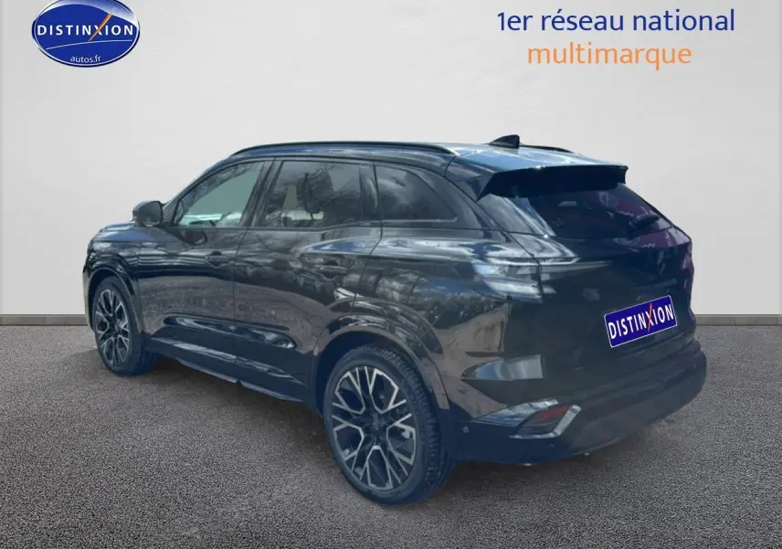 Vue 3/4 arrière droite du Renault Austral noir avec jantes alliage 20 pouces et barres de toit visibles.