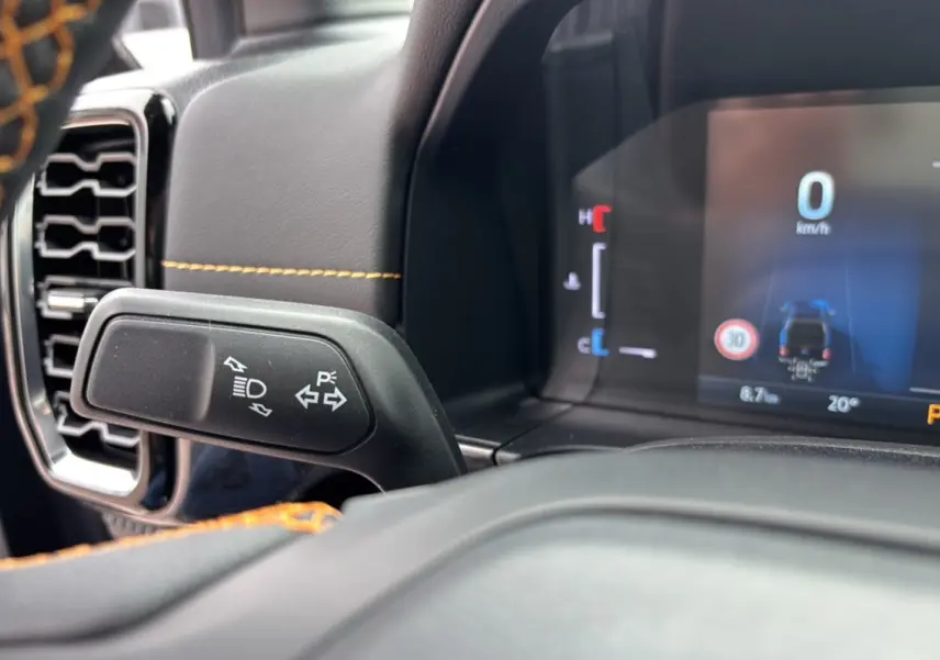 Gros plan sur le commodo gauche et le tableau de bord numérique du Ford Ranger Wildtrak Plus noir agate.
