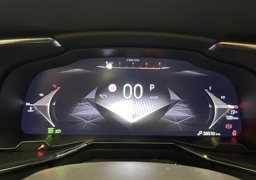 Vue rapprochée du tableau de bord numérique du DS7 2024 affichant la vitesse à 0 km/h et l'autonomie restante de 120 km.