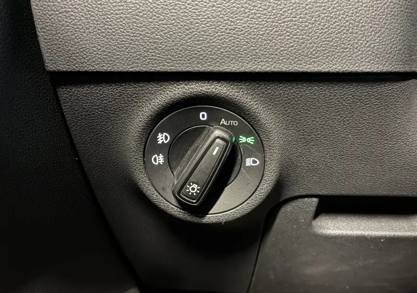 Gros plan sur le bouton de commande des phares du Skoda Karoq 2024, avec réglage automatique activé.