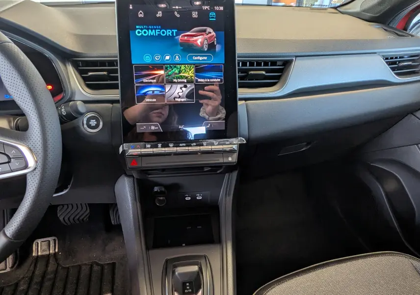 Intérieur du Renault Captur E-Tech 2025, vue centrale sur la console avec écran tactile vertical et volant partiel.