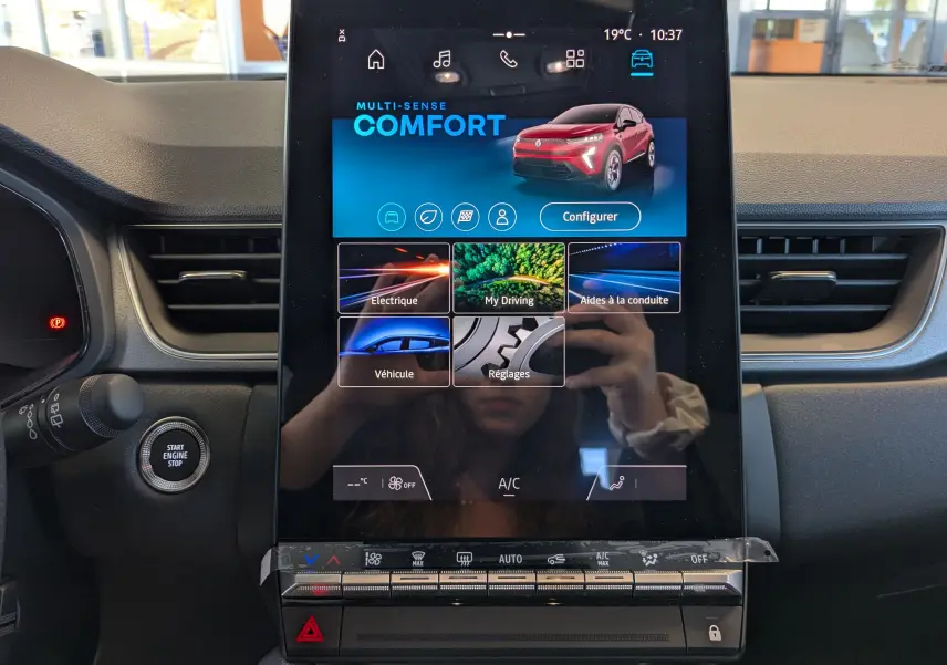 Écran tactile central du tableau de bord du Renault Captur 2025 affichant le mode Confort et une image du SUV rouge flamme.