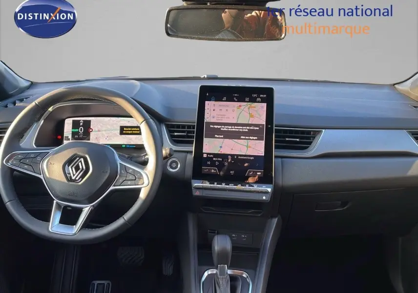 Vue intérieure du tableau de bord du Renault Captur E-Tech Hybrid 2025 avec écran tactile vertical et volant multifonction noir.