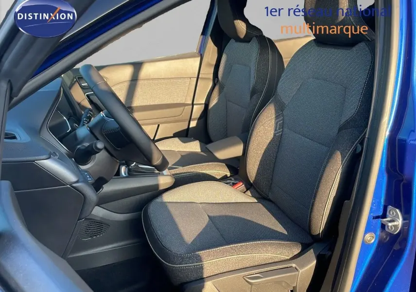 Intérieur avant droit du Renault Captur E-Tech hybride 2025 avec sièges tissu gris et portière bleu iron metal ouverte.